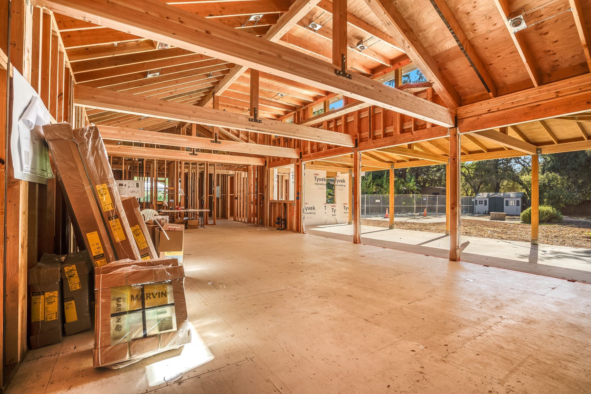 Interior view of a building under construction, featuring wooden framework and concrete floor.