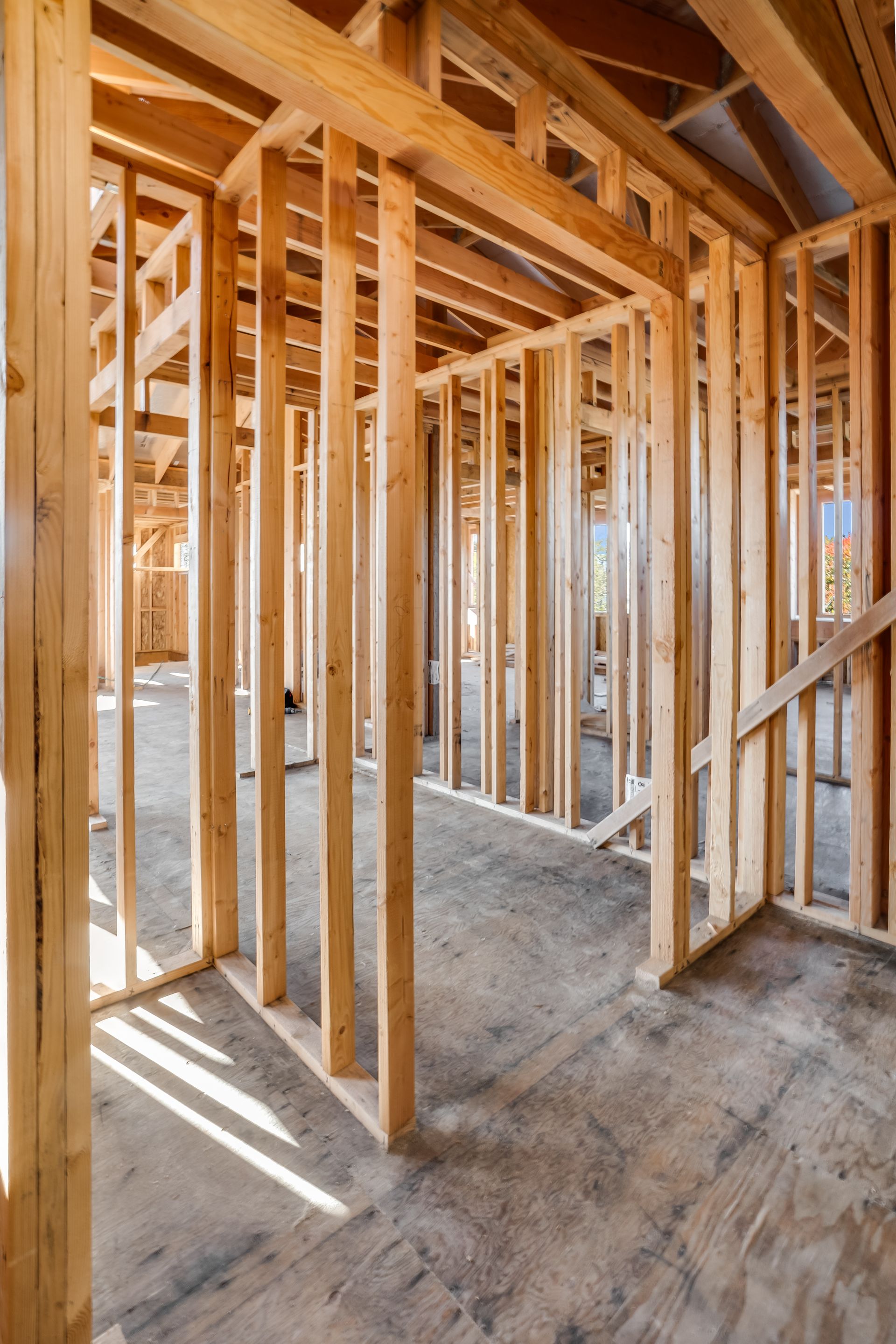 Wooden frame of a house under construction; interior view with studs and beams.