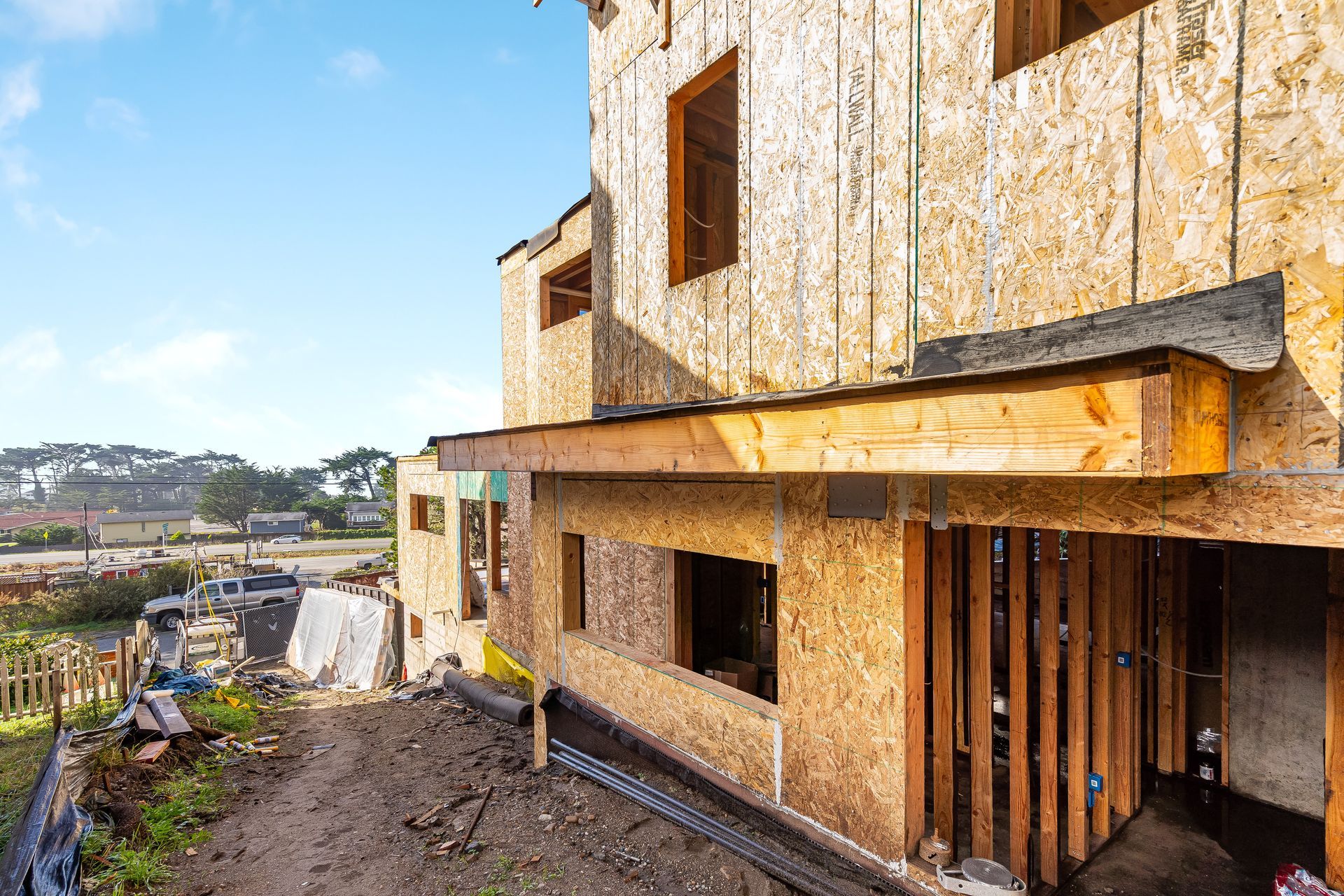 Construction of a two-story building with exposed wood framing; exterior view.
