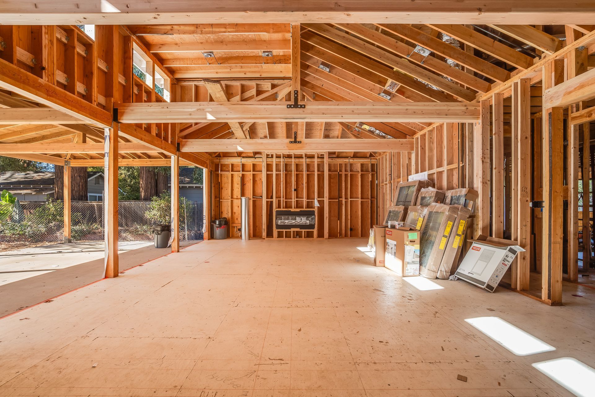 Wooden structure of a room under construction, with exposed beams and studs.