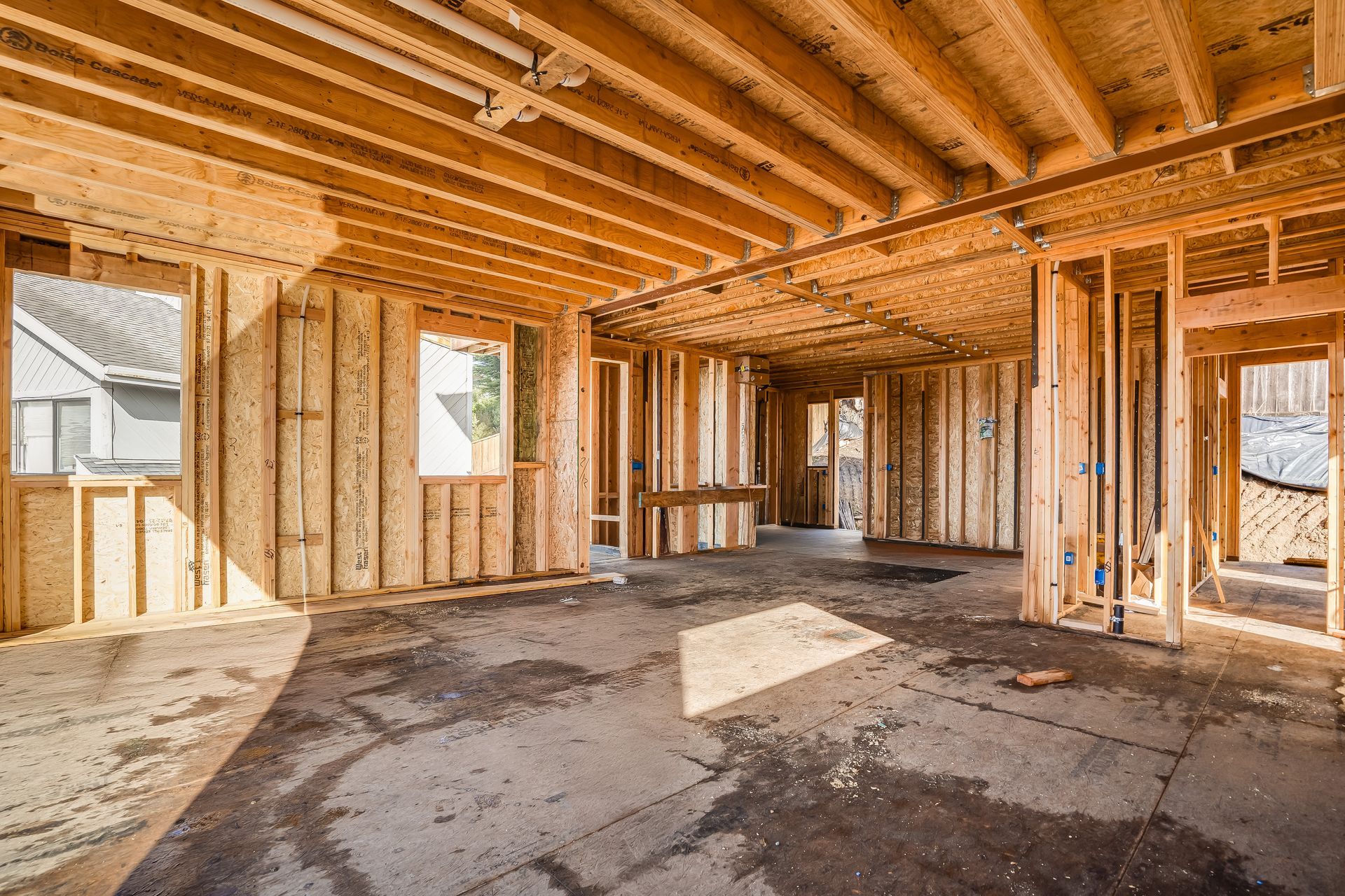 Interior view of a building under construction, showing wooden framing and exposed beams.
