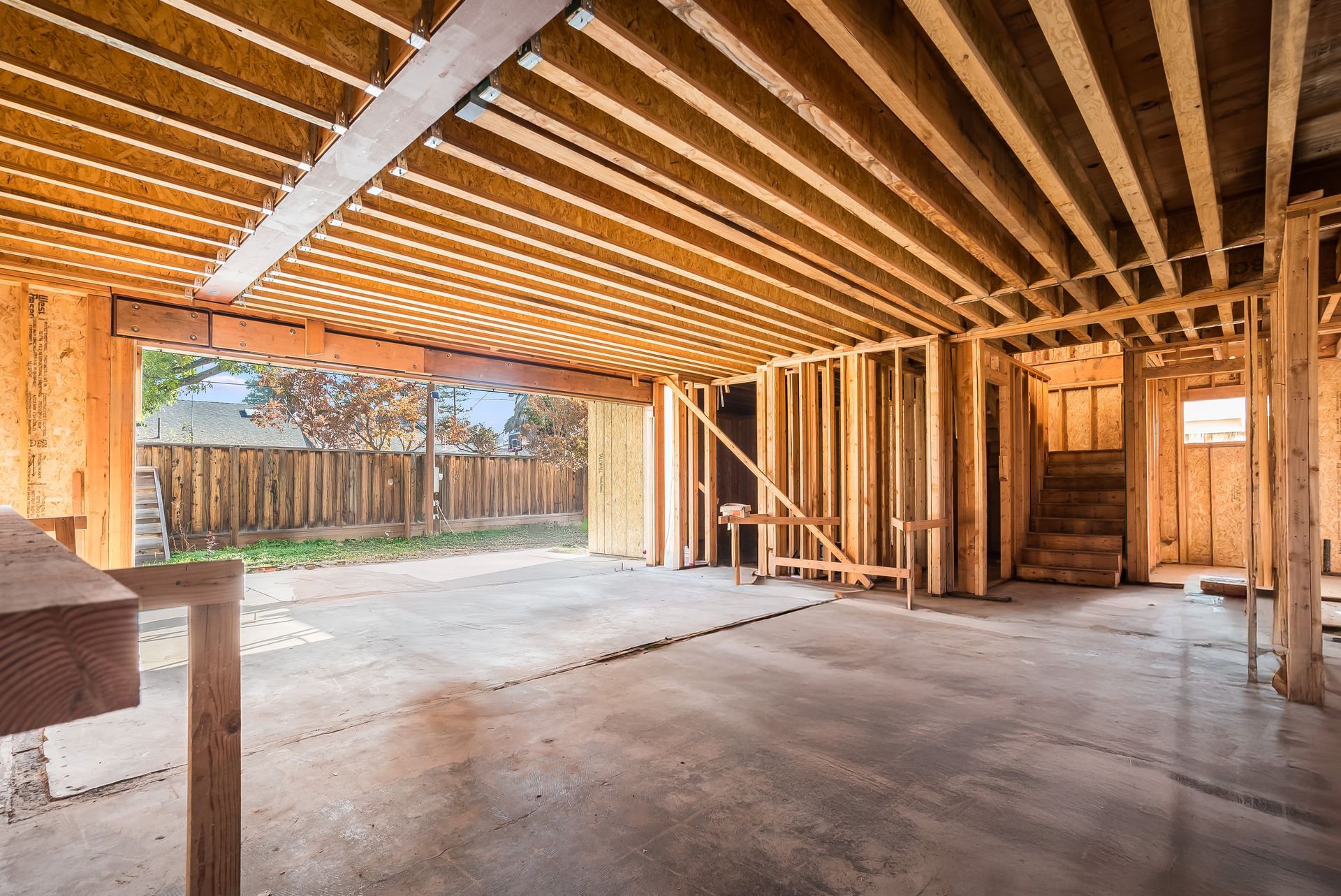 Interior view of a building under construction, showing wooden framework and concrete floor.