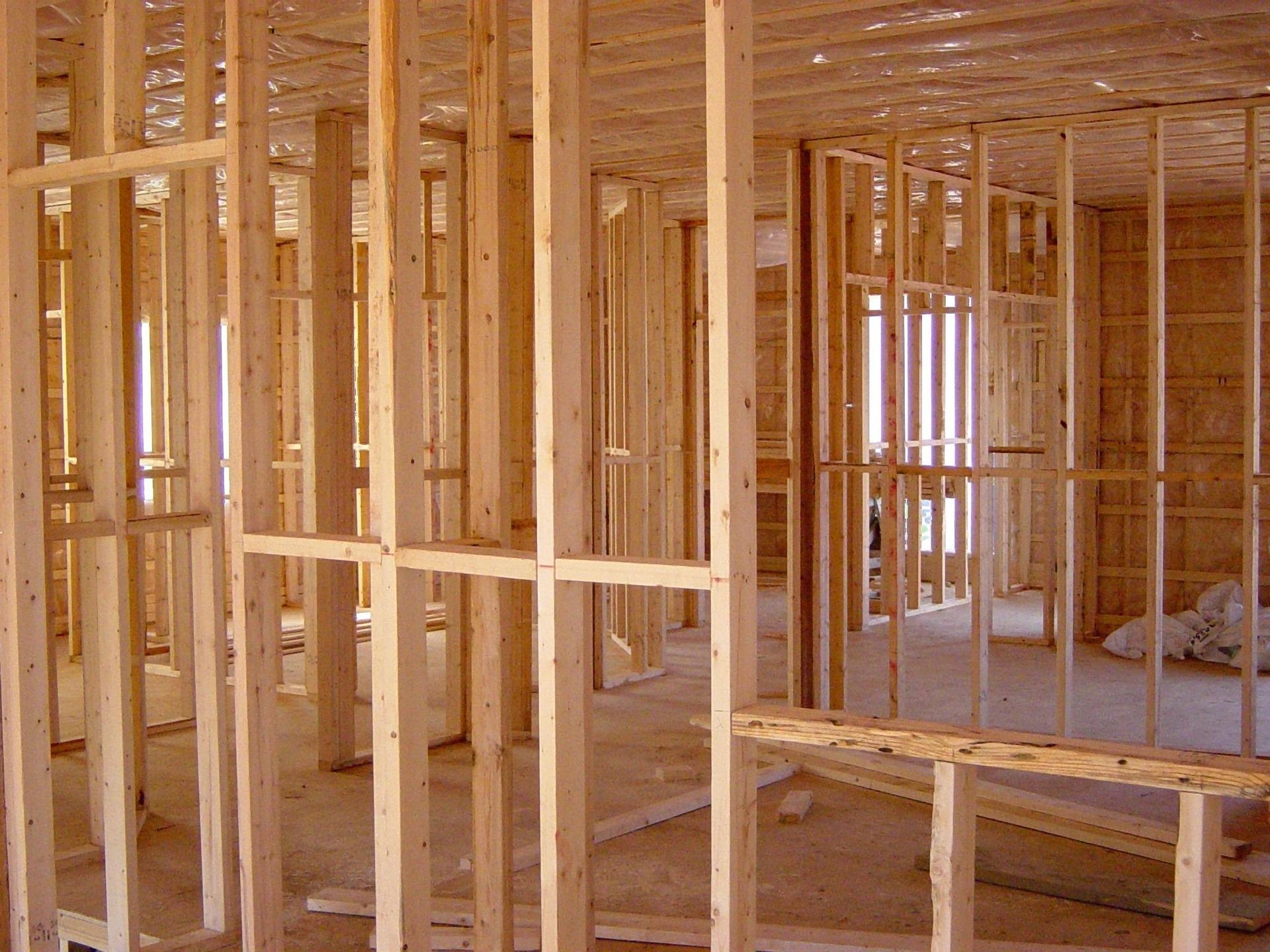 Wooden house framing; interior view of studs, doorways, and ceiling.