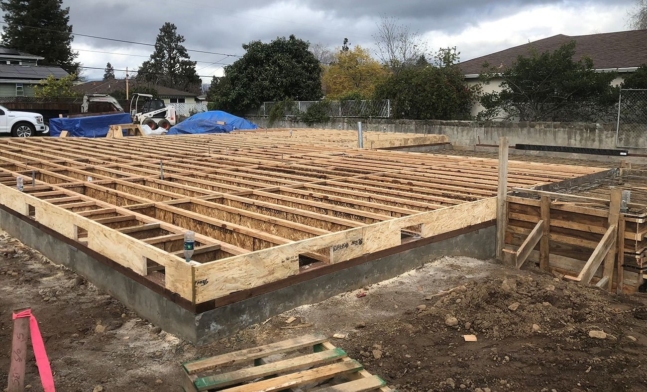 Wooden framework of a building's foundation, under construction.