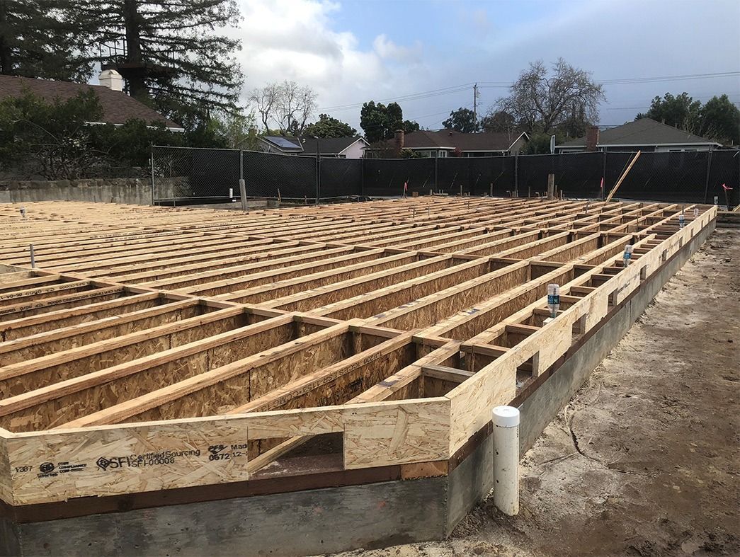 Wooden foundation framework for a building under construction, outdoors.
