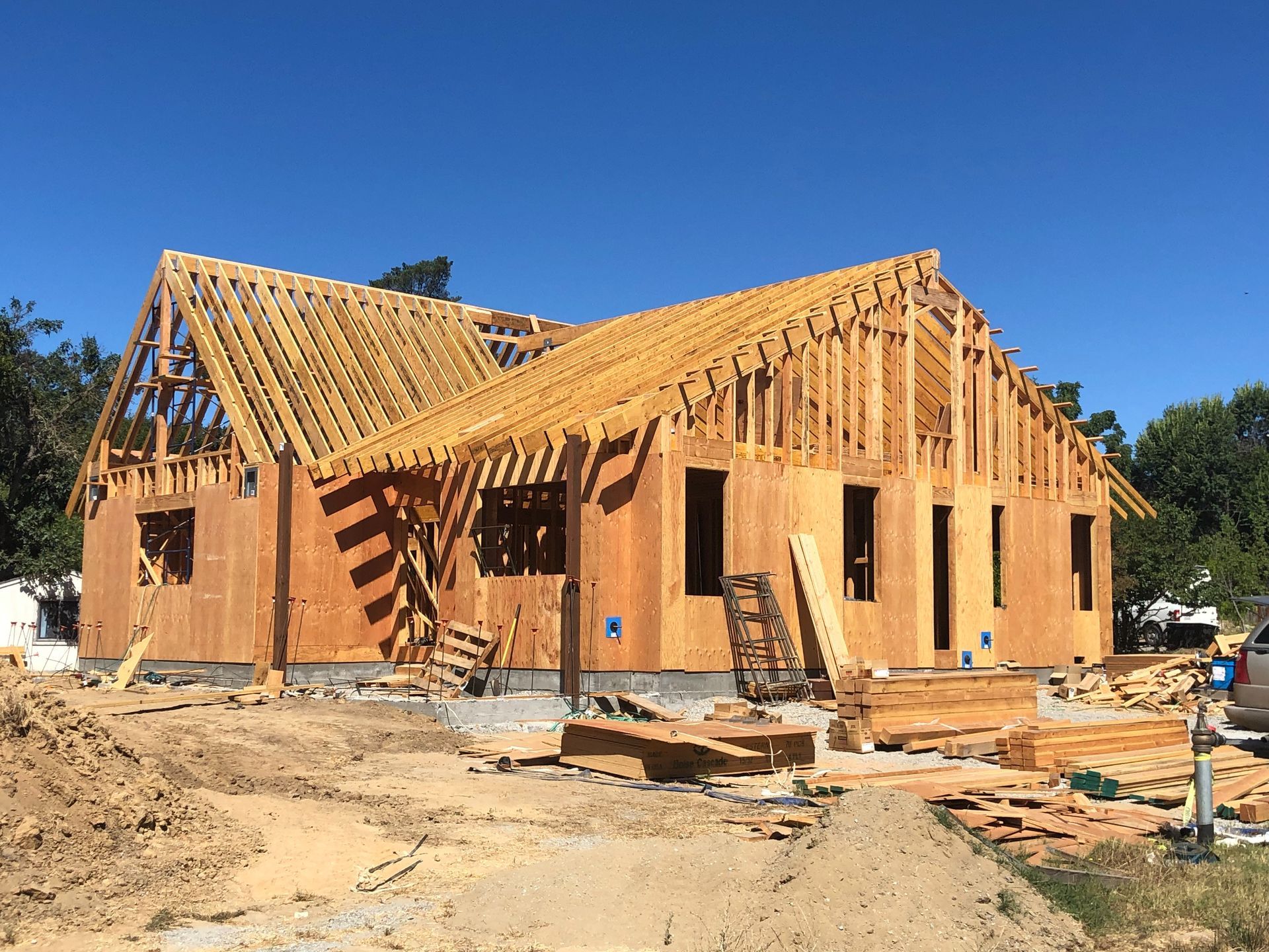 Wooden frame of a house under construction; blue sky in the background.