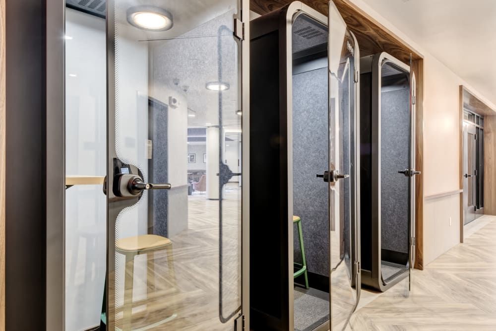 A hallway with a row of telephone booths in it.