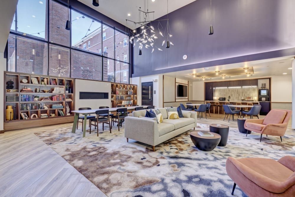 A living room with a couch , chairs , tables and a fireplace.