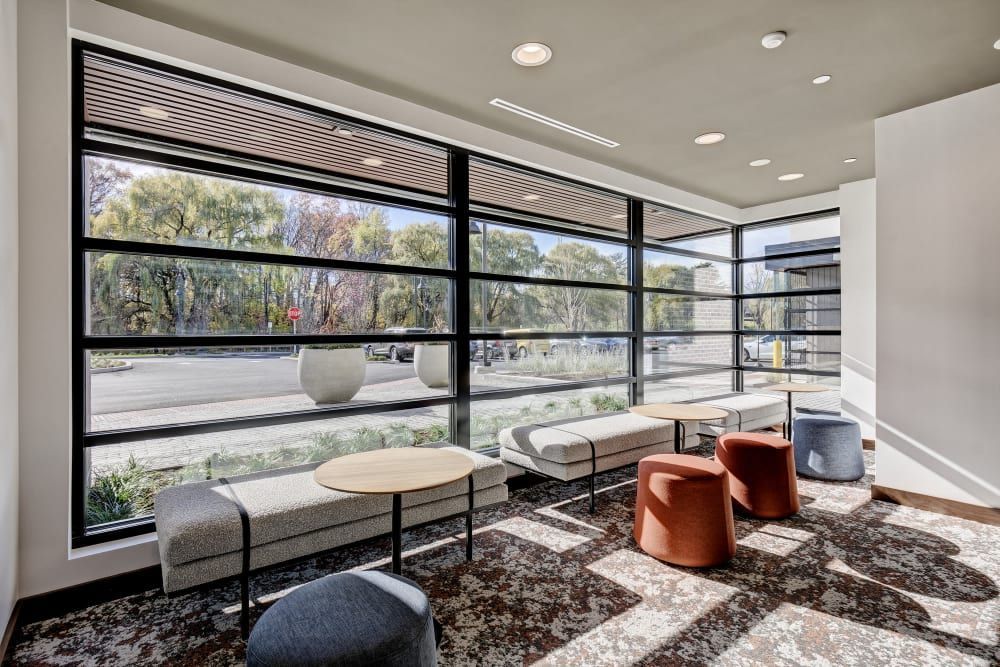 A living room with tables and chairs and a large window.