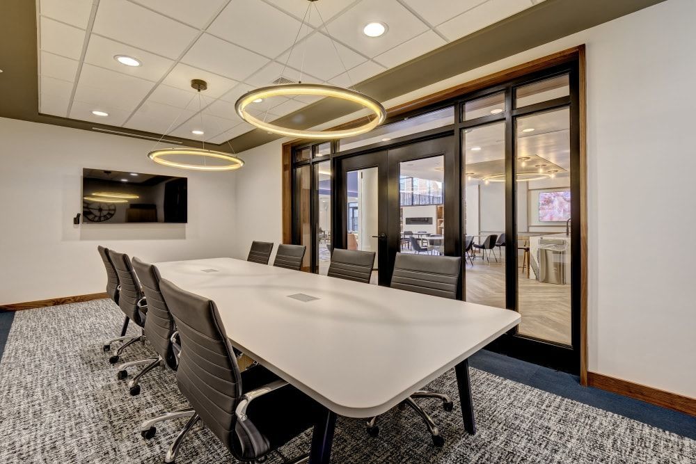 A conference room with a long table and chairs.