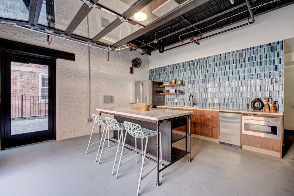 A kitchen with a large island and stools in it.