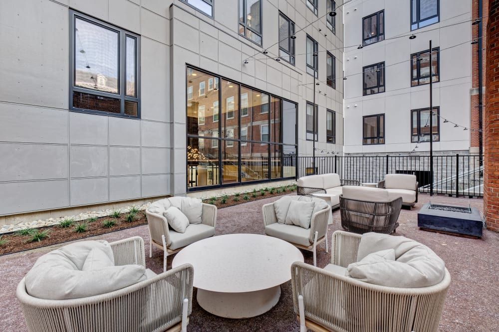 A patio with chairs and a table in front of a building.