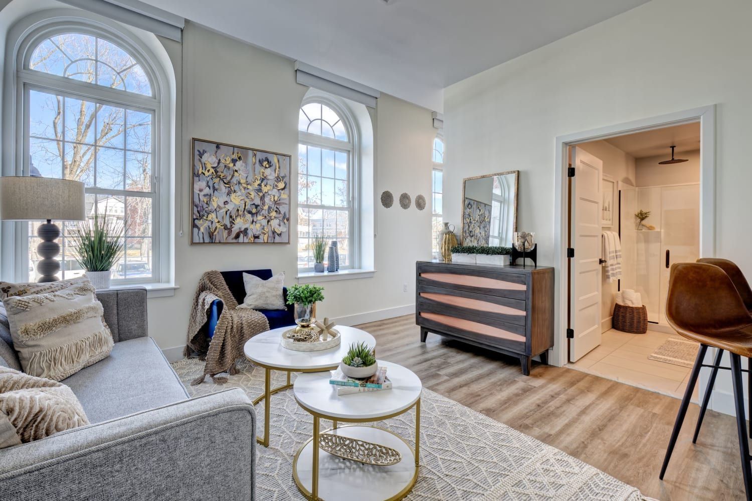 A living room with a couch , two coffee tables , and a dresser.