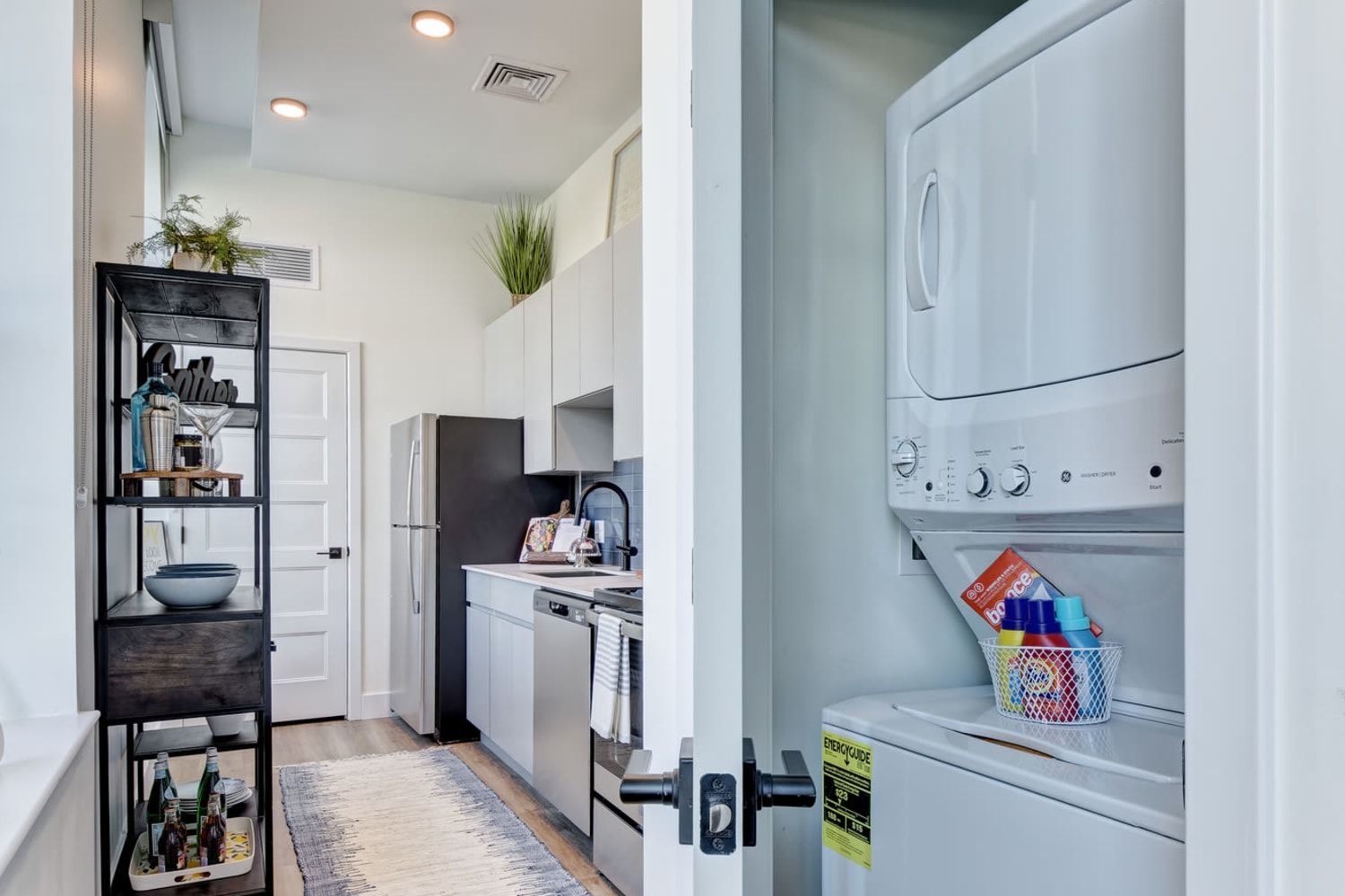 A kitchen with a washer and dryer stacked on top of each other.