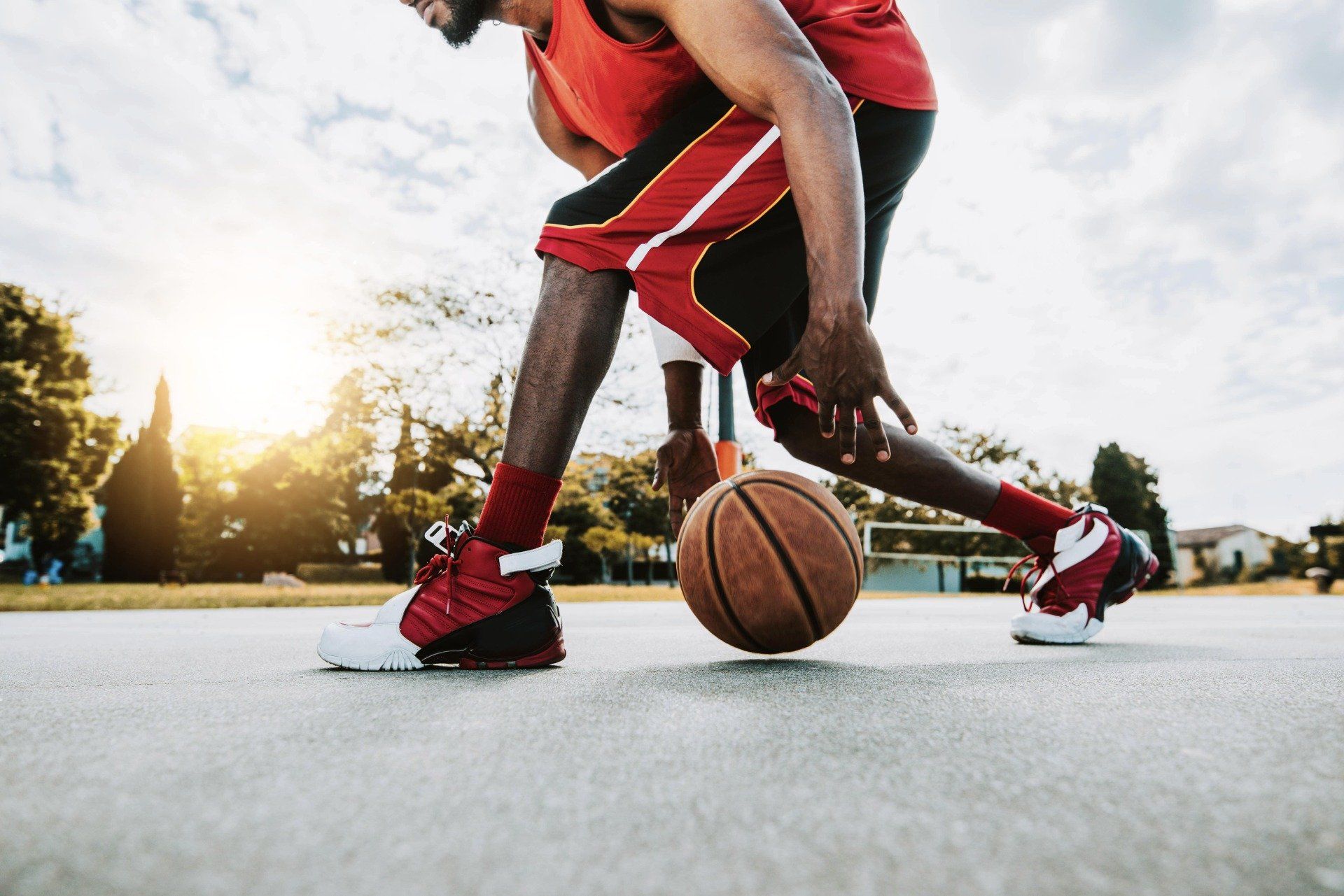 basketball player dribbling with ball on asphalt basketball court