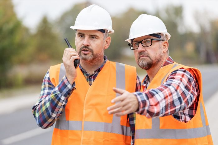 road construction workers talking to walkie talkie