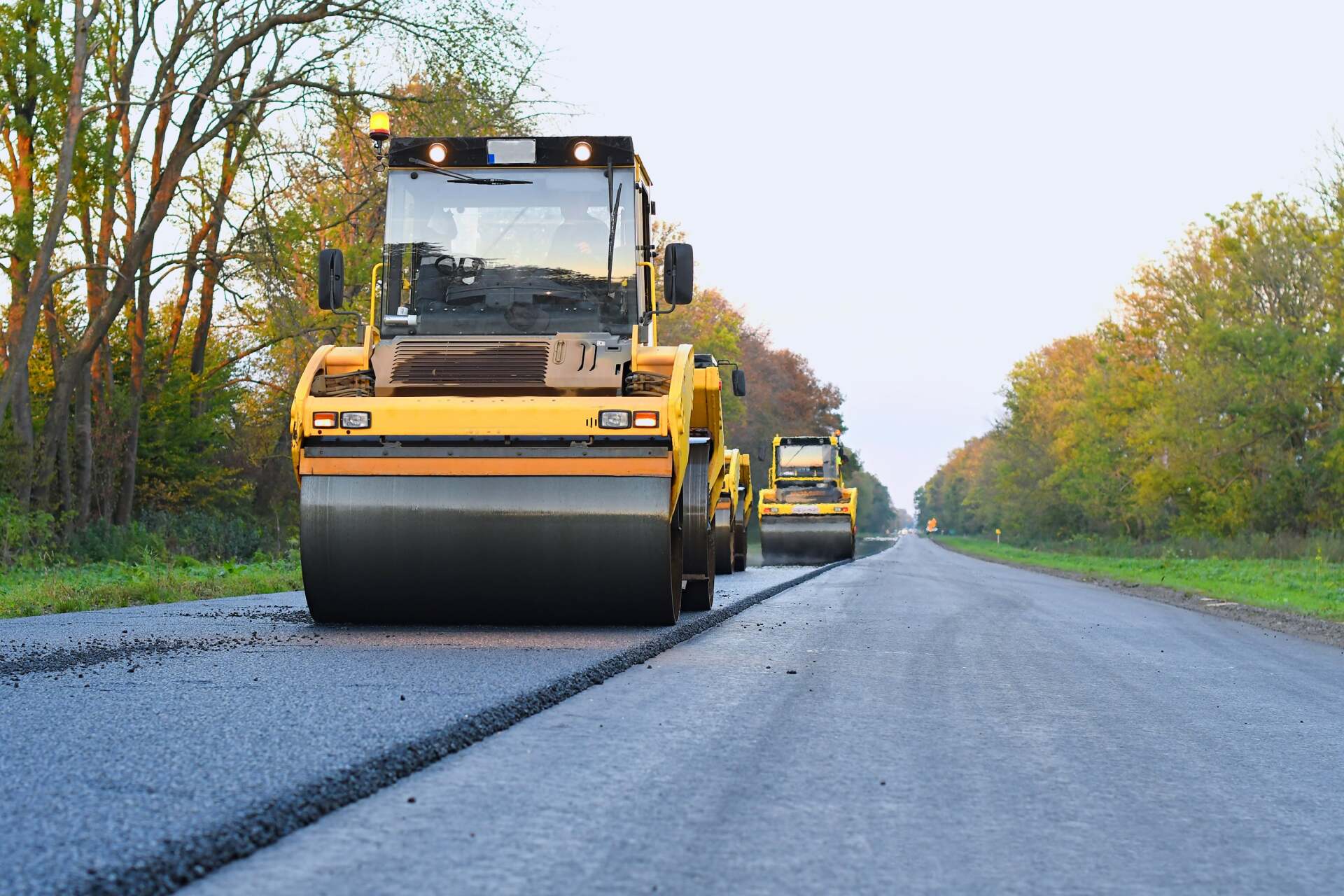 worker leveling fresh asphalt on a road construction