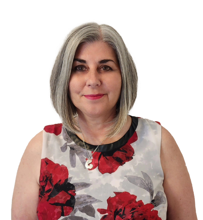 Woman with gray hair, smiling, wearing a floral print sleeveless top with red and black accents.