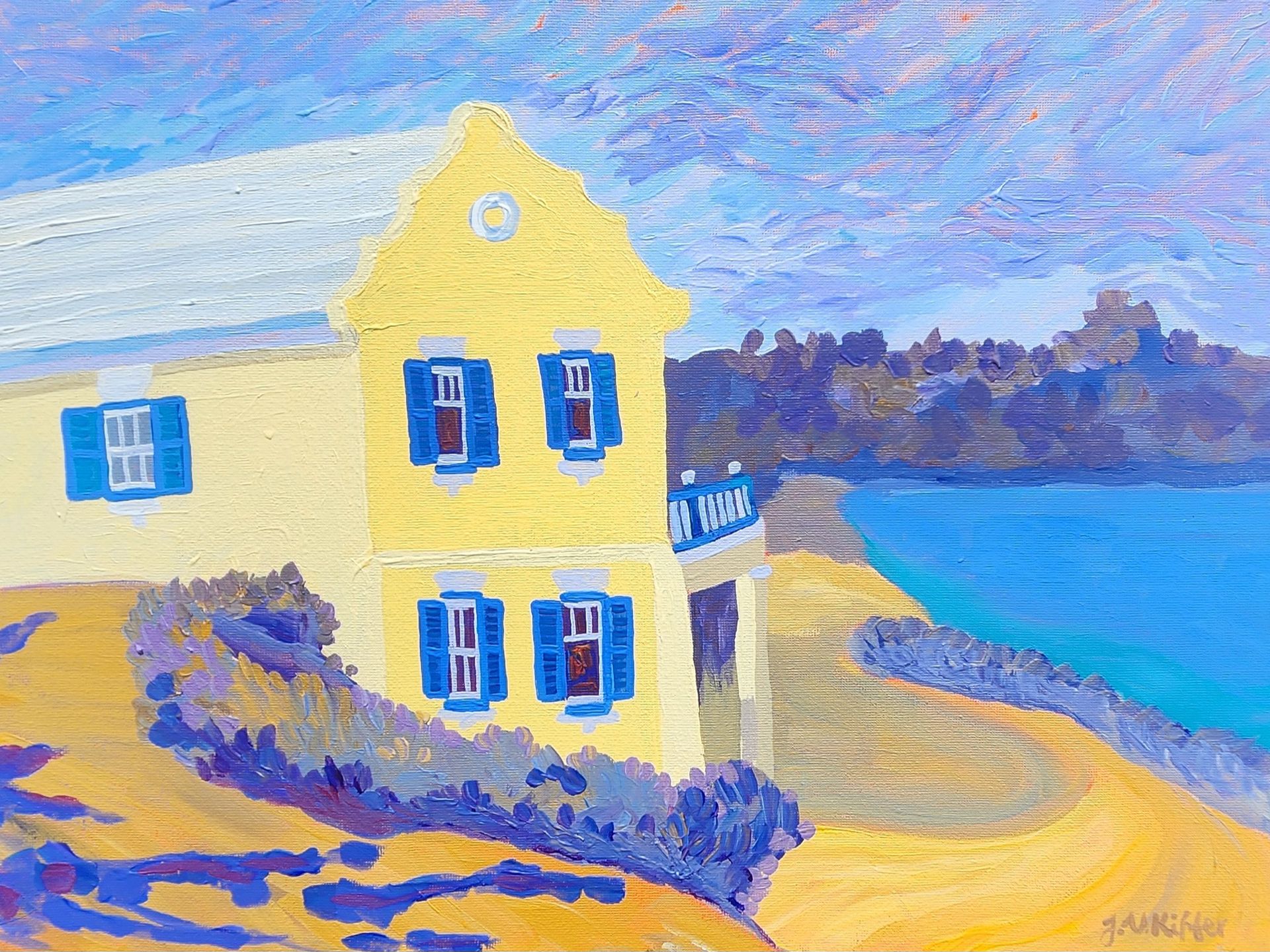 Yellow house with blue shutters overlooking a blue sea.