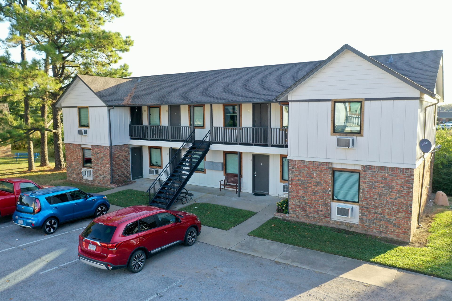 a group of cars are parked in front of a apartment building .