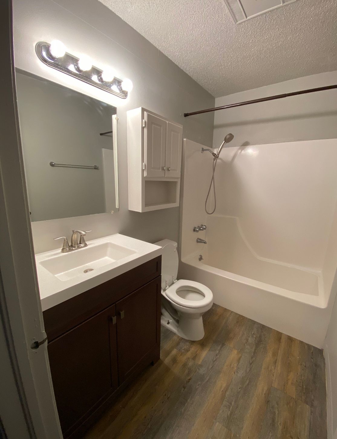 a bathroom with a sink , toilet , bathtub and mirror .