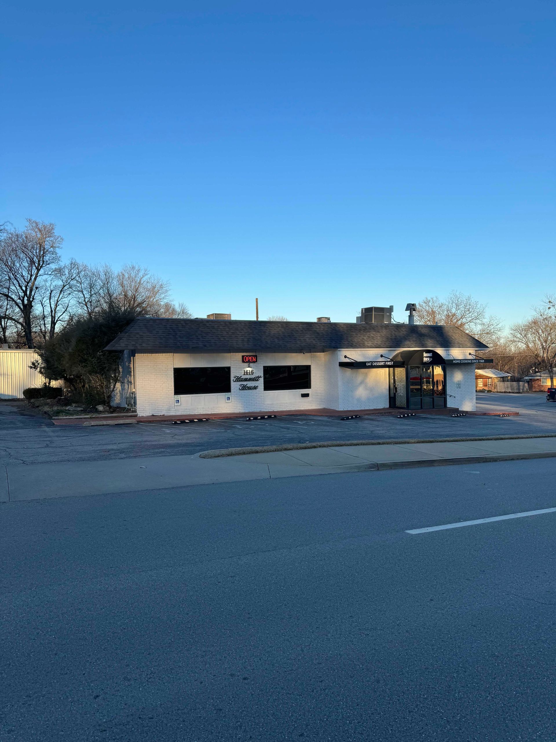 a small white building is sitting on the side of the road .