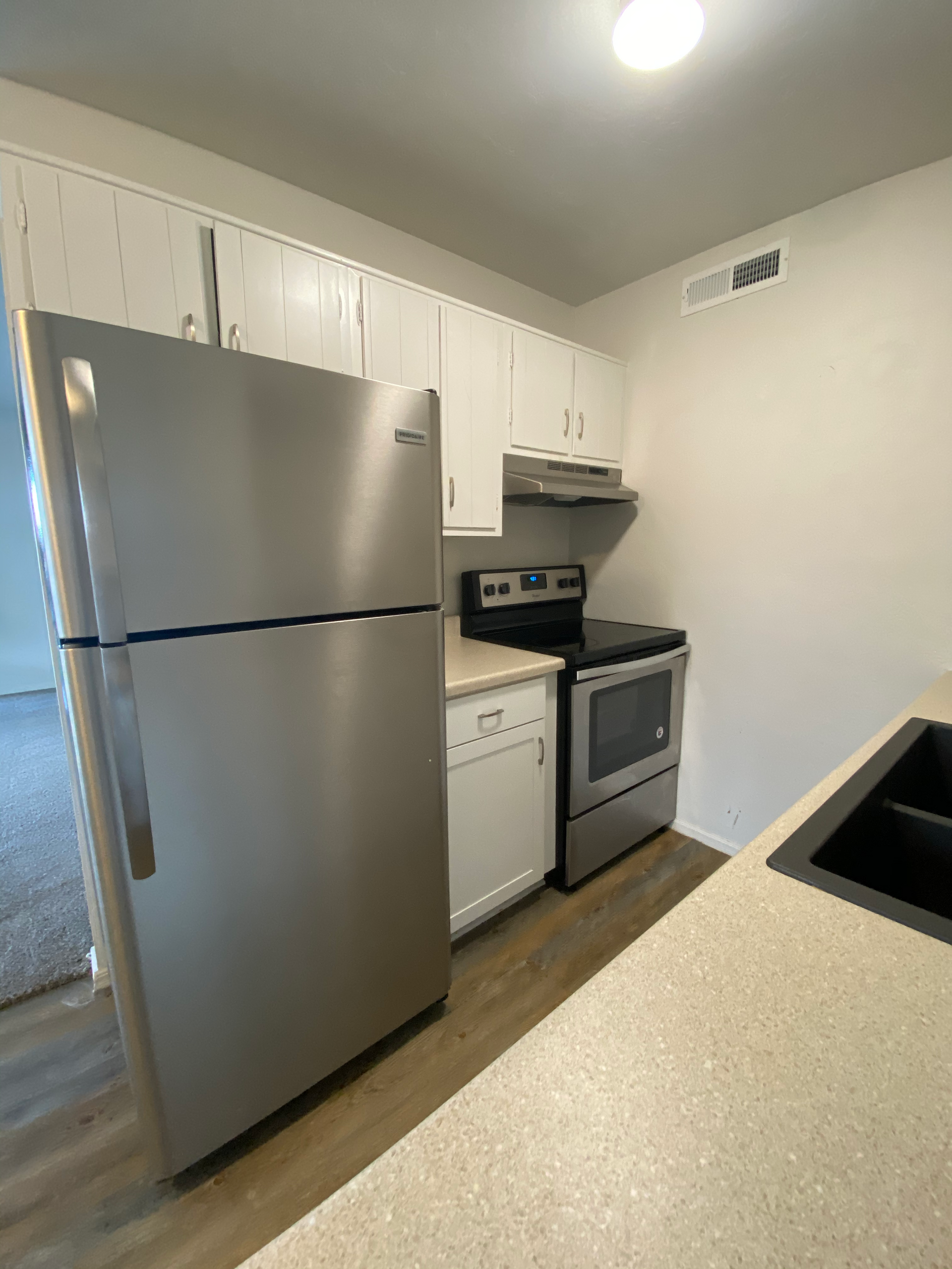 a kitchen with a refrigerator , stove , dishwasher and sink .