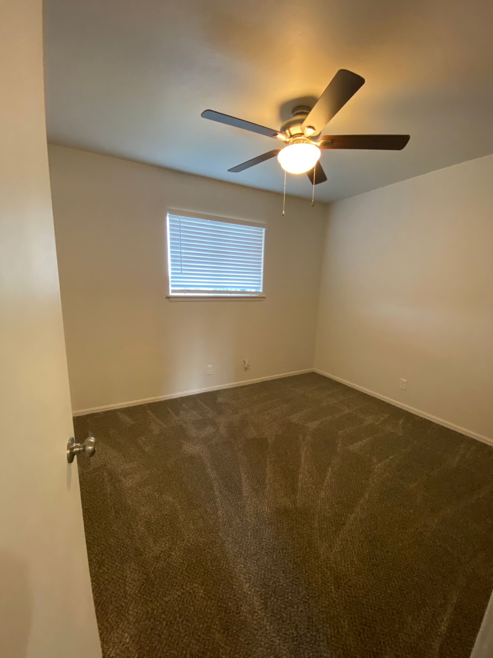 a bedroom with a ceiling fan and a window .