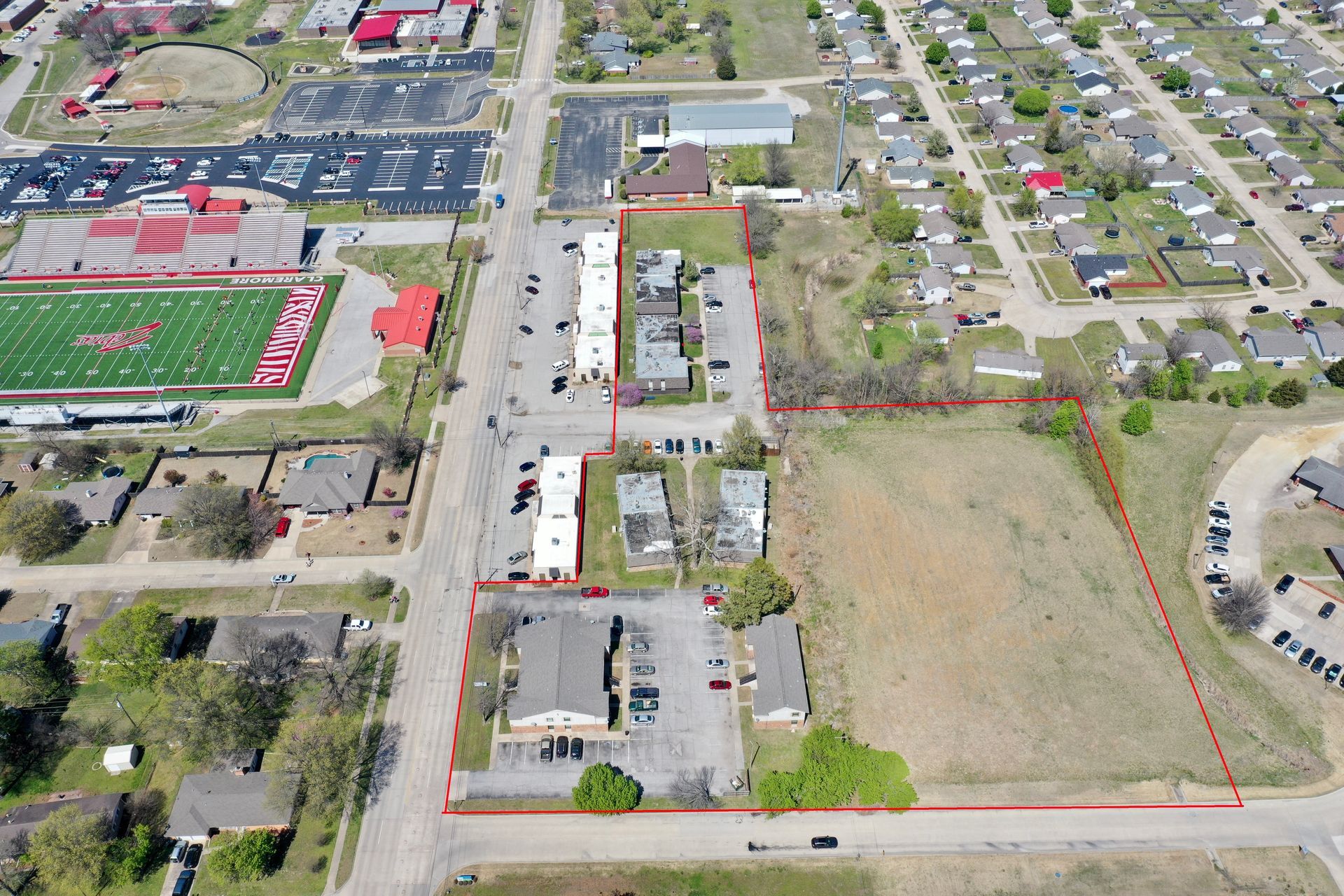an aerial view of a residential area with a football field in the background .