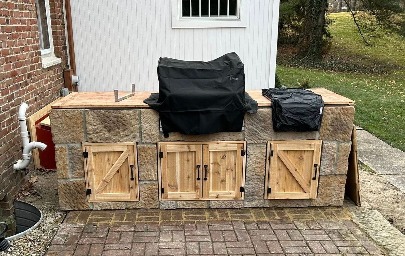 A stone walkway with rocks and a bush in the background.