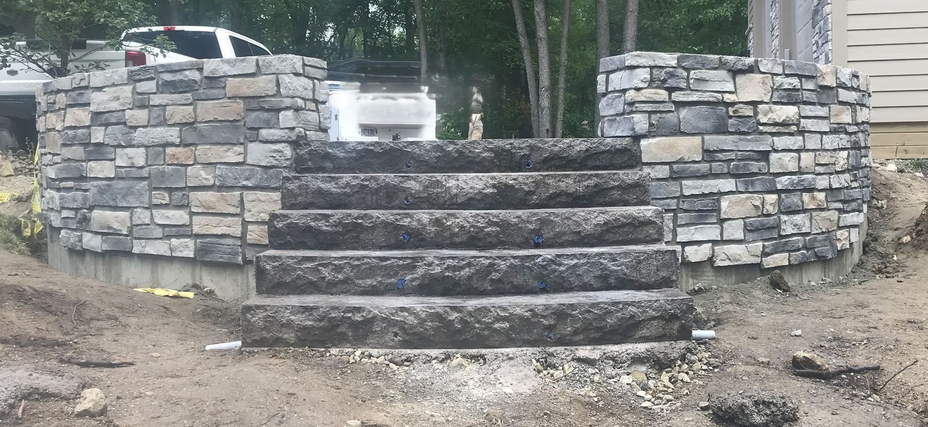 A white bucket is sitting on top of a pile of bricks.