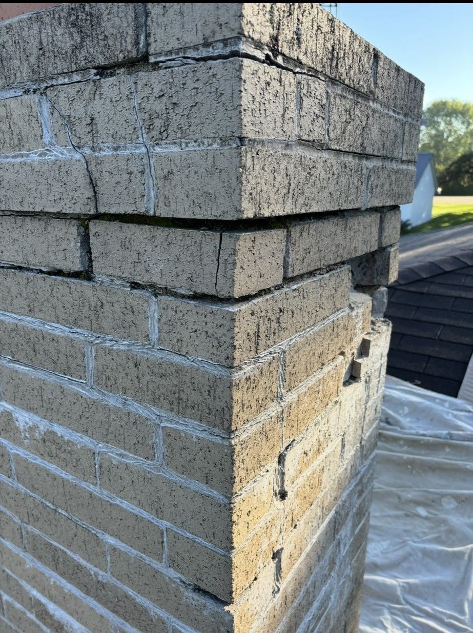 A close up of a brick chimney on a roof.