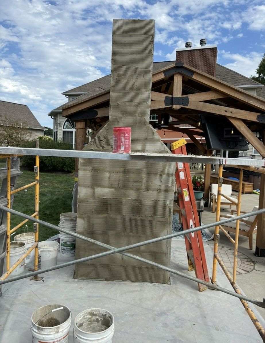 A chimney is being built in front of a house.