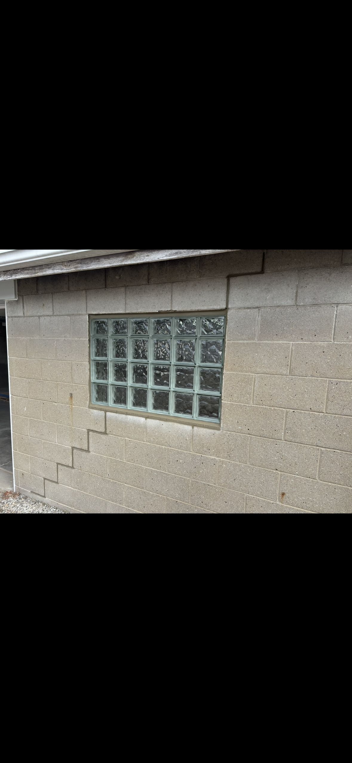 A rusty star is hanging on a brick wall.