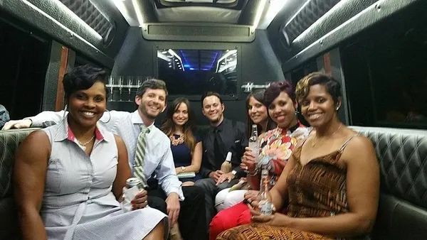 A group of people are sitting in a limousine.