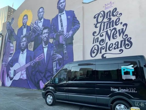A van is parked in front of a mural that says one time in new orleans