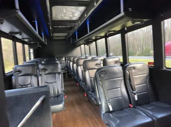 The inside of a bus with many seats and shelves