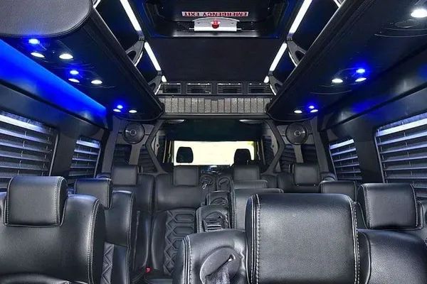 The inside of a van with lots of seats and blue lights.