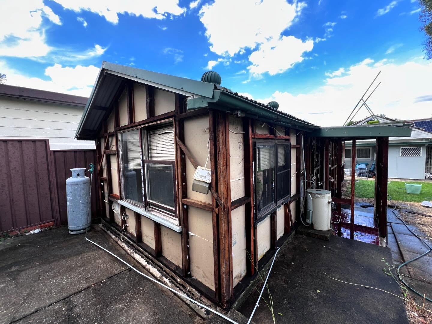 Small, Aged Shed With Wood Trim and Damaged Siding — Ecowave Solutions In Gosford, NSW