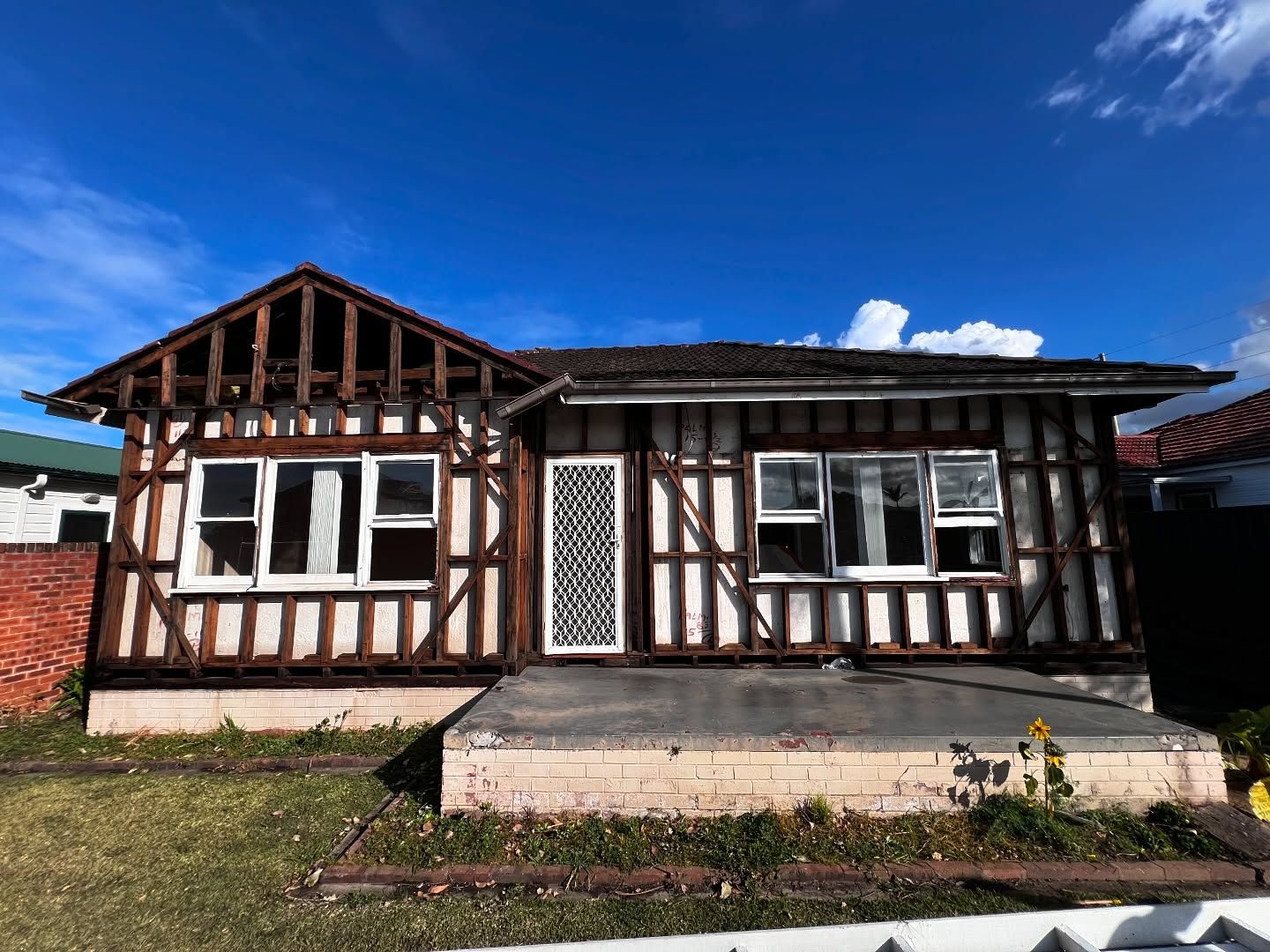 House With Exposed Wooden Framework; Tudor Style Facade, Blue Sky — Ecowave Solutions In Gosford, NSW