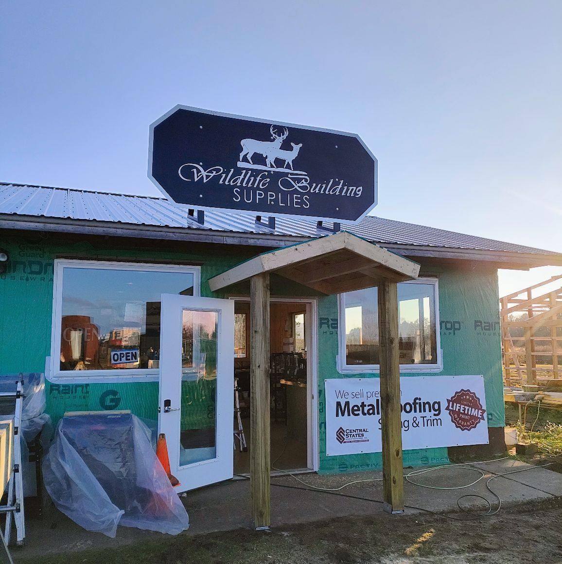 A green building with a sign that says wildlife creations