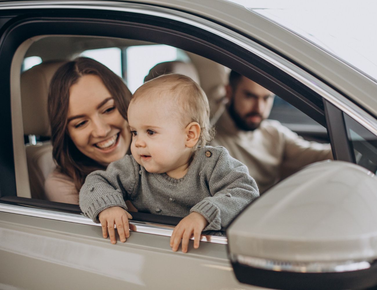 A woman and a baby are sitting in a car.