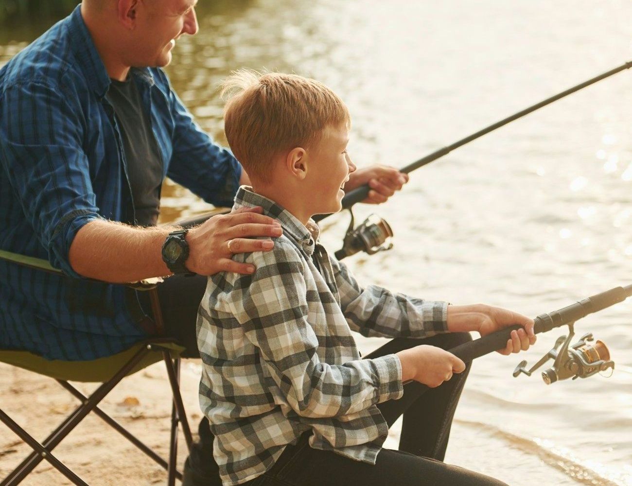 A man and a boy are fishing on a lake.