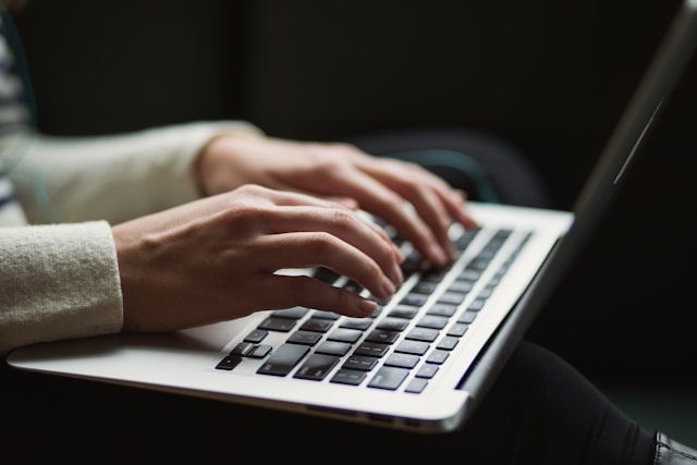 A person is typing on a laptop computer.