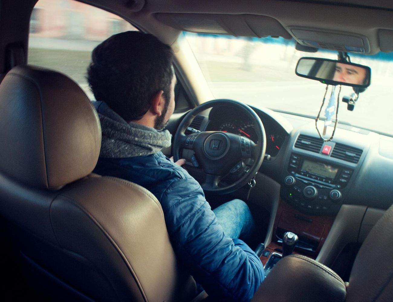 A man is sitting in the driver 's seat of a car.