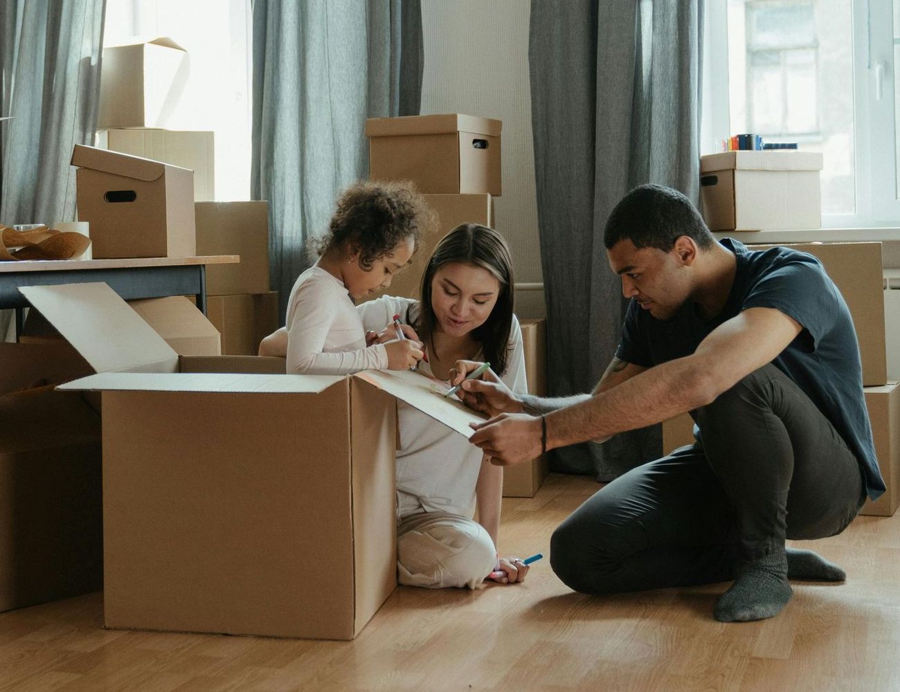 A family is moving into a new home and playing with cardboard boxes.