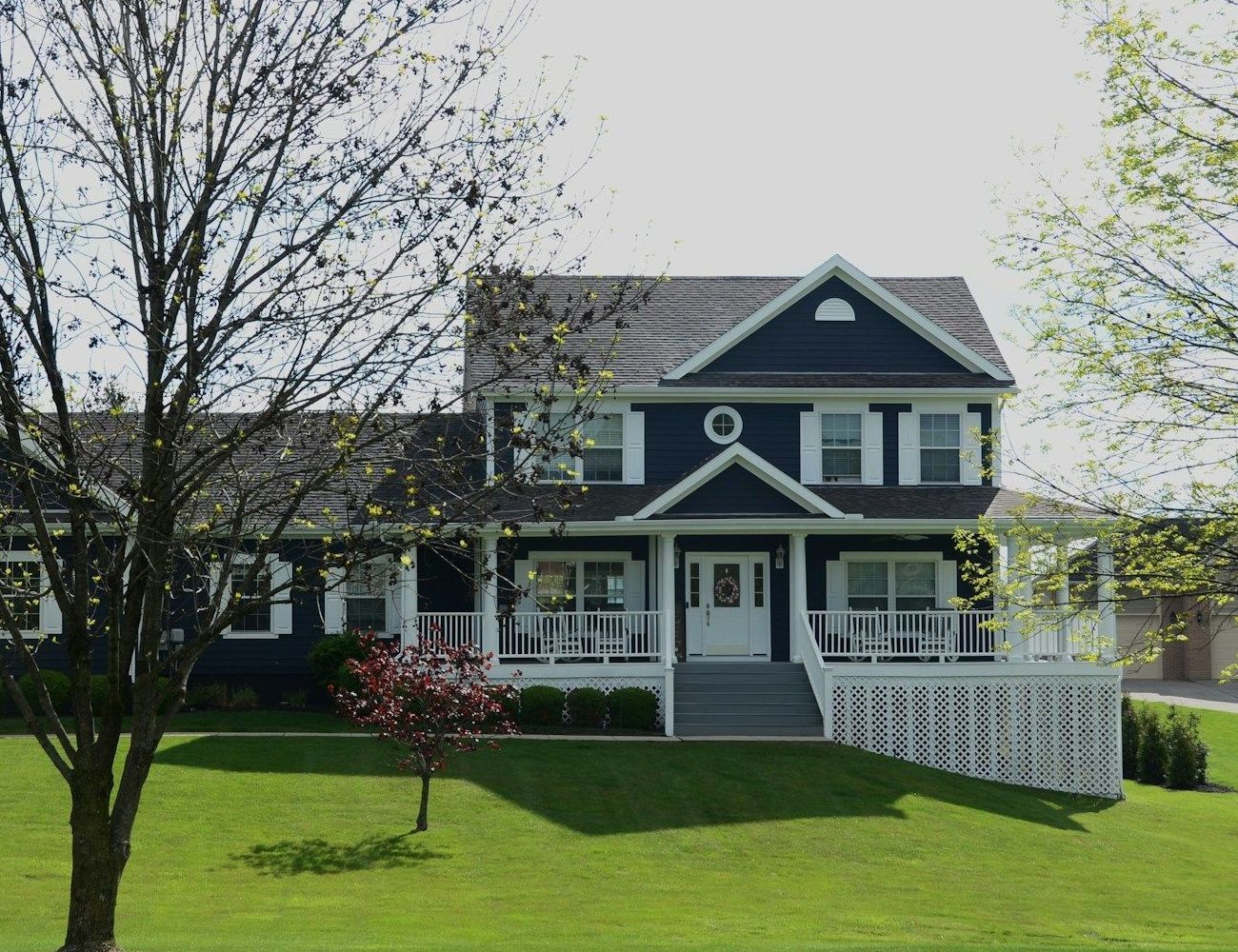 A large black and white house with a large porch