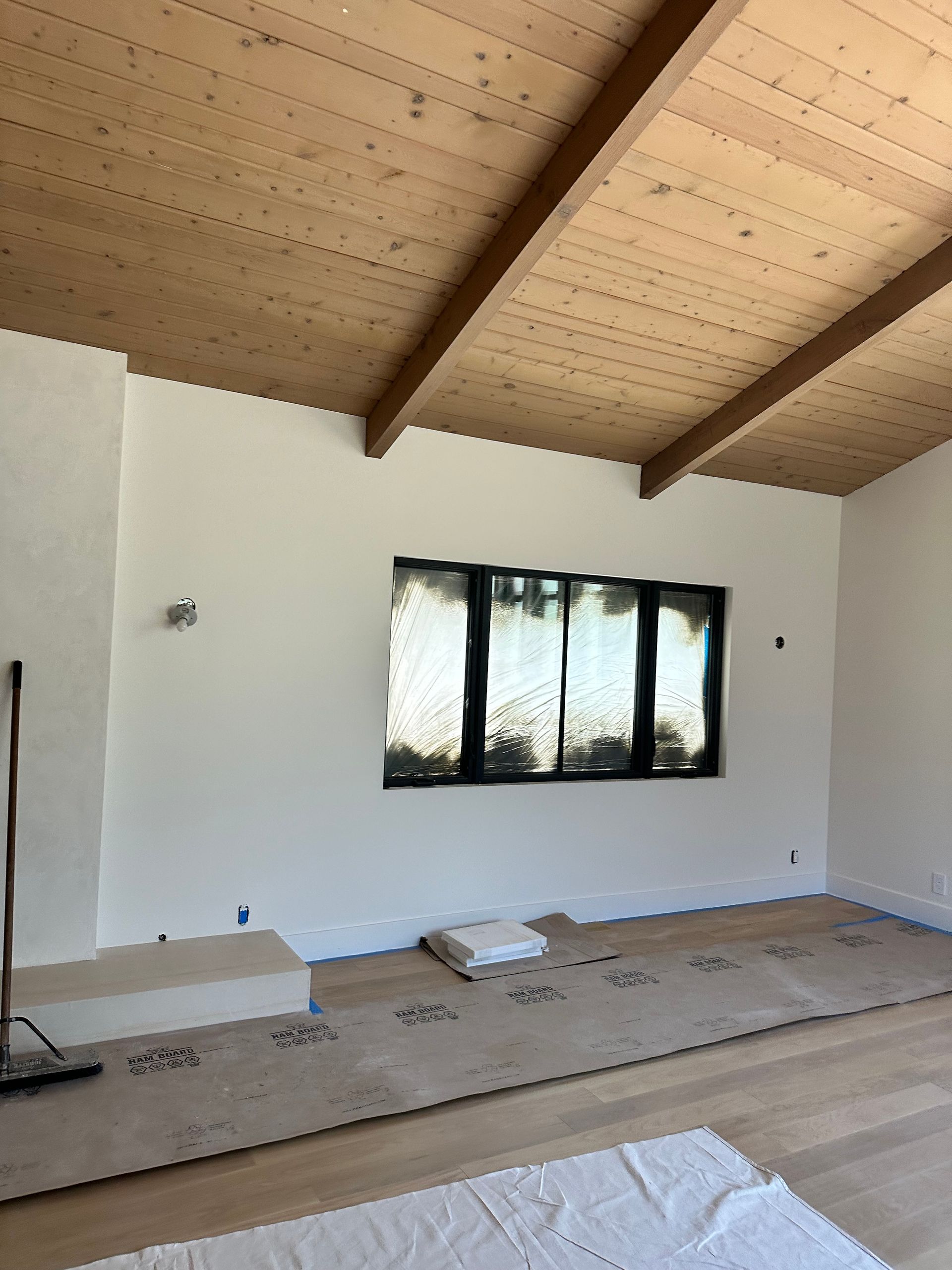 A room with a wooden ceiling and white walls