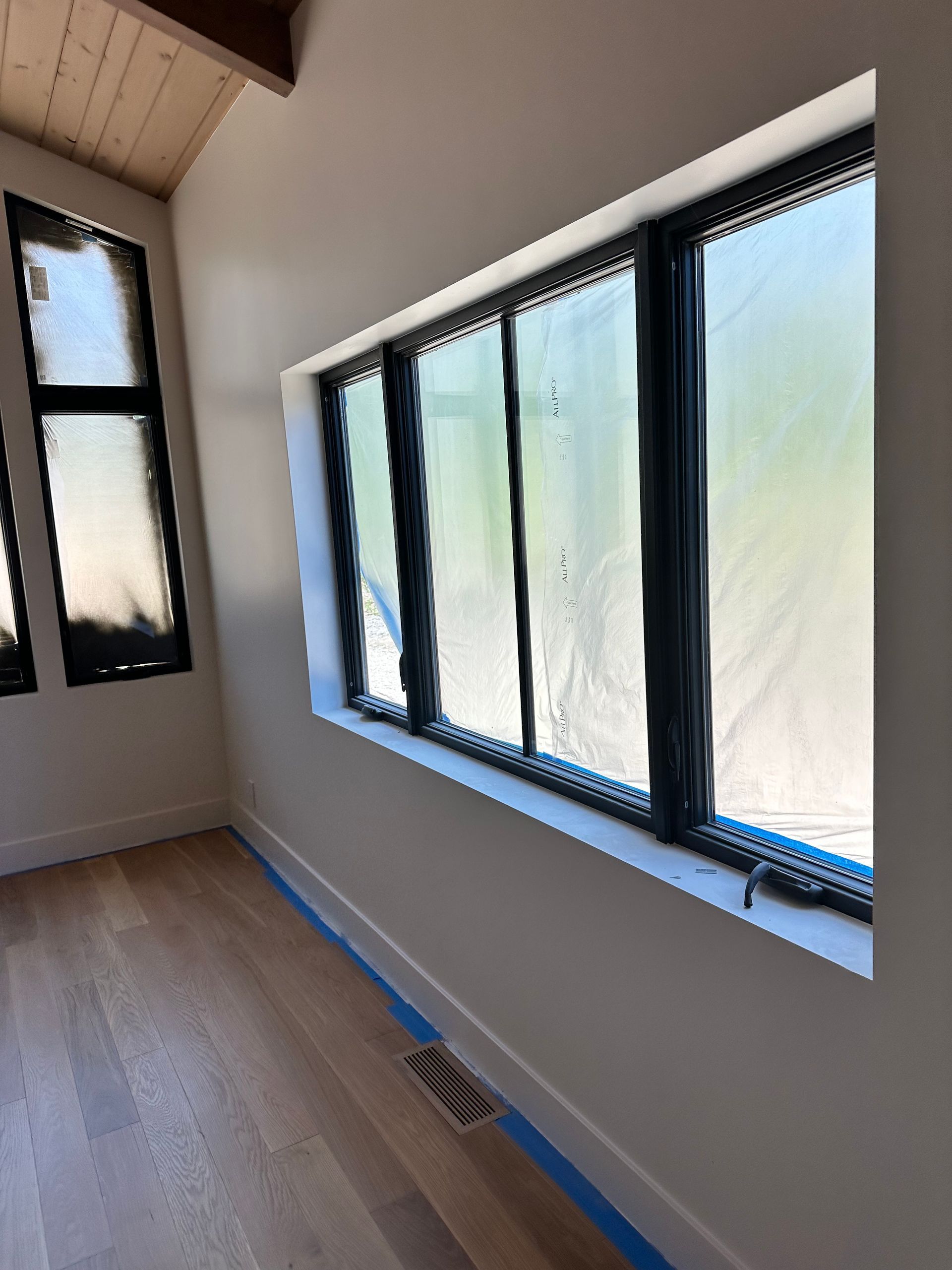 A room with a lot of windows and a wooden floor.