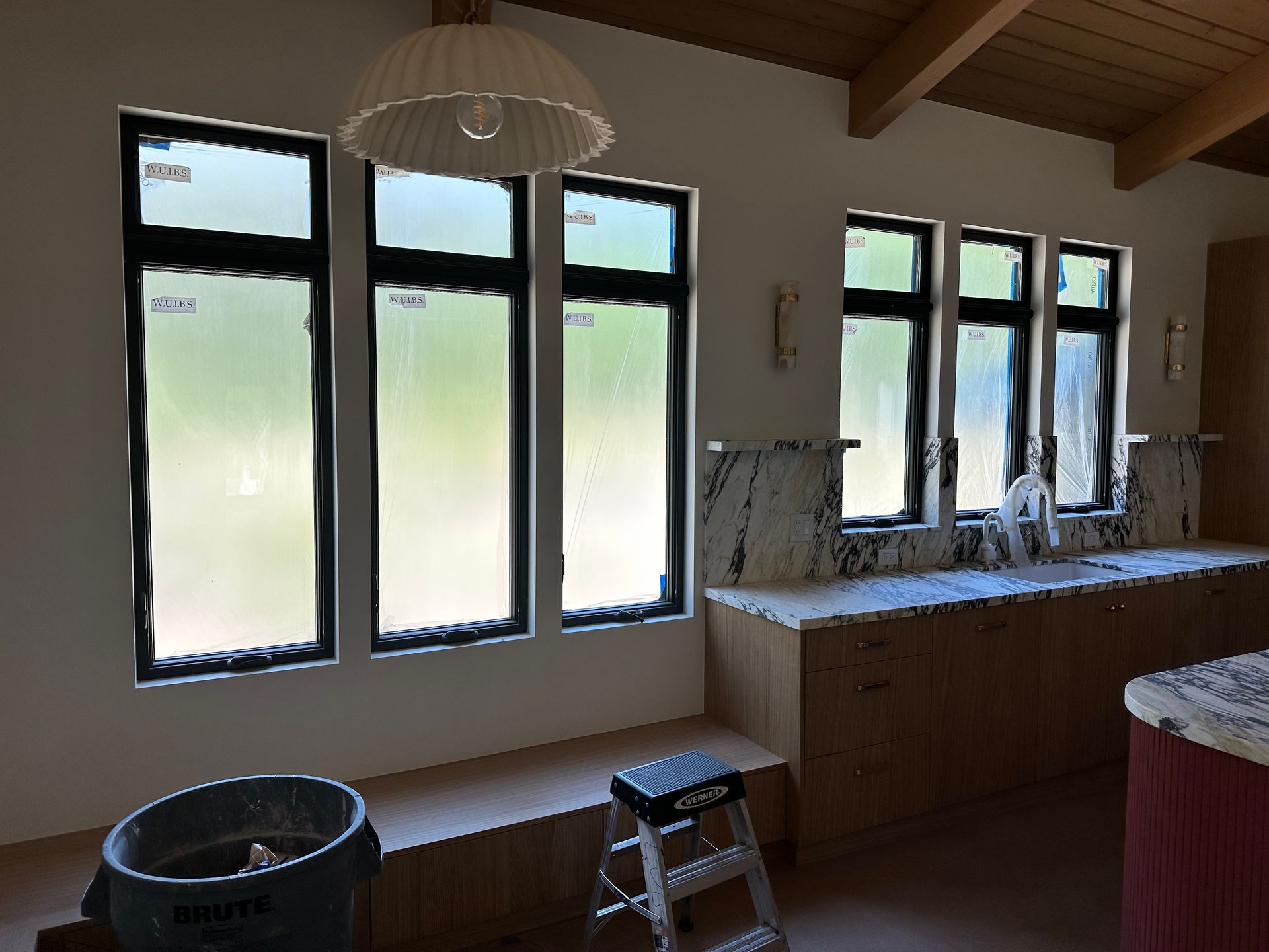 A kitchen with a lot of windows and a ladder